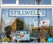  ?? PHOTOS BY ALYSSA POINTER / ALYSSA.POINTER@AJC.COM ?? The storefront of Stillwell’s Emporium displays racial justice solidarity signs in downtown Stone Mountain, a small DeKalb County city in the shadow of the famous mountain that memorializ­es the Confederac­y.