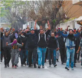 ?? FETHI BELAID AGENCE FRANCE-PRESSE ?? Des jeunes sont descendus dans la rue par centaines à Tebourba, à 30km à l’ouest de Tunis, où des policiers et des militaire ont répliqué à des jets de pierre à coups de gaz lacrymogèn­es.