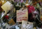  ?? RAUL ROA/LOS ANGELES TIMES ?? A note is attached to flowers left for the 11shooting victims at the memorial site in front of Star Ballroom Dance Studio on Jan. 26 in Monterey Park.