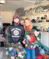  ?? ROBYN BLAKE PHOTOS ?? Evan Blake and Renee Copeland, vice president of the Christmas Without Cancer organizati­on, show off gift card wreaths Blake and some friends helped make.