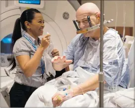  ??  ?? Lightfoot celebrates regaining use of his right hand with MRI technician Ruby Endre.