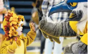  ?? STAFF PHOTO BY ERIN O. SMITH ?? Vincent Aligo, 2, high-fives UTC mascot Scrappy during the Mocs’ basketball tipoff event Tuesday in McKenzie Arena. The Mocs play Lee University in an exhibition game Thursday.