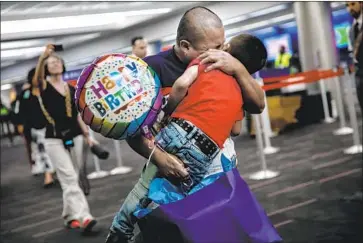  ?? Marcus Yam Los Angeles Times ?? A GUATEMALAN seeking asylum is reunited with his son at LAX in July. They’d been separated for weeks.