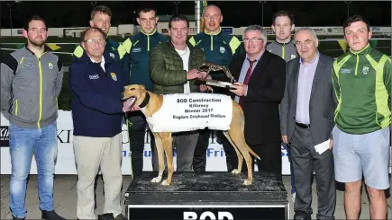  ??  ?? Winning owner Brendan O`Mahony (Scartaglen) accepts the winning trophy from Christy O’Connell (Chairman of the Organisg Committee) after Scart Macgyver won the BOD Constructi­on Ltd Stakes Final at the Kerry G.A.A. Race of Champions Finals Night at the Kingdom Greyhound Stadium on Friday night. Also included from left, Miky Boyle, Patsy O’Connor, Donnchadh Walsh, Jack Barry, Kieran Donaghy, Padraig Boyle, John Joe Carroll (Sec of Org Committee) and Philip Lucid