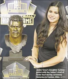  ?? GETTY ?? Junior Seau’s daughter Sydney poses with her father’s Hall of Fame bust during ceremony Saturday in Canton, Ohio.