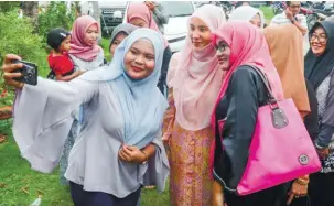  ?? BBXPIX ?? ...Permatang Pauh member of parliament Nurul Izzah Anwar (centre) obliging guests at a ‘kenduri rakyat’ at Kampung Kubang Hulu in Penanti.