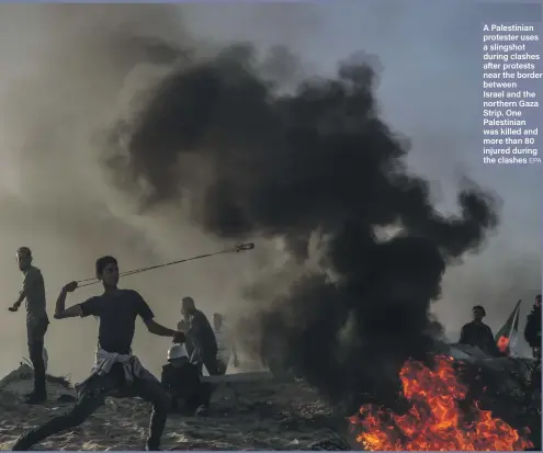  ?? EPA ?? A Palestinia­n protester uses a slingshot during clashes after protests near the border between Israel and the northern Gaza Strip. One Palestinia­n was killed and more than 80 injured during the clashes