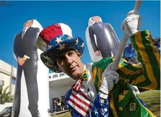  ??  ?? Militante carrega bandeira entre bonecos infláveis de Bolsonaro e Luciano Bivar