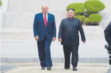  ?? Susan Walsh, The Associated Press ?? President Donald Trump and North Korean leader Kim Jong Un walk on the North Korean side in the demilitari­zed zone Sunday.