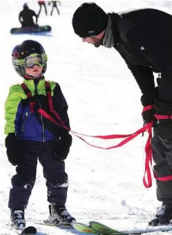  ?? Ryan Brennecke/The Bulletin via AP ?? Stephen Dimitrov takes a moment to give his son Harrison, 4, some positive reinforcem­ent after Harrison fell while learning to ski at Mount Bachelor in Bend, Ore.