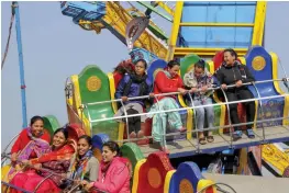  ?? — PTI ?? People enjoy rides at a park as they celebrate Basant Panchmi in Cheharta on the outskirts of Amritsar on Thursday.