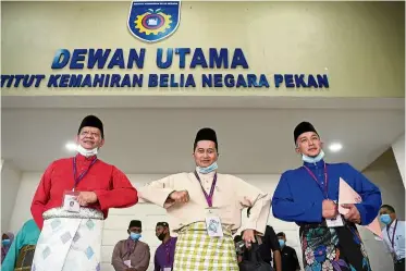  ?? — Bernama ?? Keeping their distance: (From left) Tengku Zainul, Shukri and Sharim giving each other elbow bumps as they arrive for the nomination process at Institut Kemahiran Belia negara in Pekan.