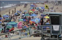  ?? THE ASSOCIATED PRESS ?? A lifeguard scans a crowded shoreline at Manhattan Beach. California’s population has stalled at 39million people. An estimate released Friday showed the state had 39.96million people as of July 1.