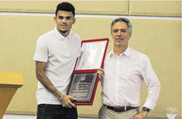  ??  ?? Luis Díaz recibe una placa de manos del presidente del Junior, Alejandro Arteta.