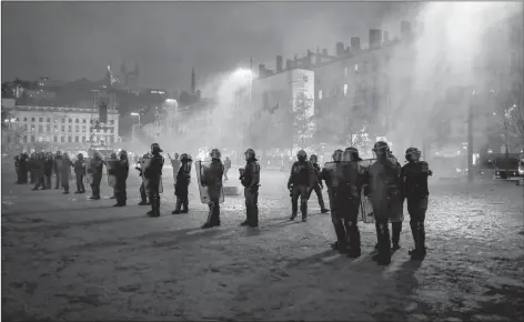  ?? AP PHOTO ?? Police officers face demonstrat­ors in Lyon, central France, Saturday. The grassroots movement began as resistance against a rise in taxes for diesel and gasoline but quickly expanded to encompass frustratio­n at stagnant incomes and the growing cost of living.