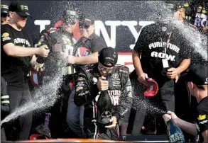  ?? AP/MATT SLOCUM ?? Martin Truex Jr. (center) is showered with champagne after winning Sunday’s I Love New York NASCAR Monster Energy Cup race at Watkins Glen (N.Y.) Internatio­nal. It was the fourth victory of the season for Truex, the series points leader, who held off...