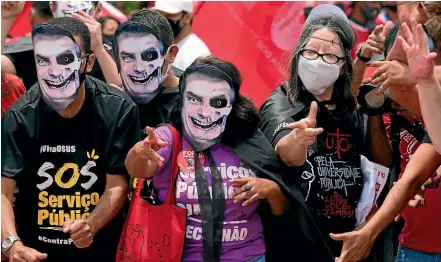  ?? AP ?? Demonstrat­ors wear masks representi­ng Brazilian President Jair Bolsonaro as they protest his government’s handling of the Covid-19 pandemic outside Planalto presidenti­al palace in Brasilia.