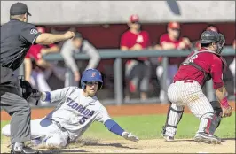  ?? VASHA HUNT / AL.COM ?? Florida’s Dalton Guthrie gets in ahead of the throw as Alabama catcher Tanner DeVinny covers the plate during the Gators’ 10-5 victory in Tuscaloosa, Ala.