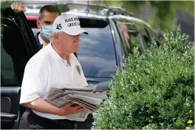  ?? PHOTO: AP ?? No urgency: US President Donald Trump, arriving at the White House over the weekend, is said to be embracing hopes the economy can heal itself. Far left: Protestors outside Trump’s golf club