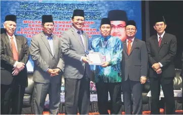  ??  ?? Dr Abdul Rahman (third left) presents the certificat­e for ‘jurunikah’ (person authorised to handle solemnisat­ion of a Muslim marriage) to one of the participan­ts, witnessed by Misnu (second left) and others.