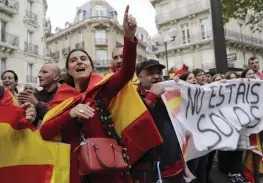  ?? — AFP ?? People, holding Spanish national flags and standing behind a banner reading ‘You are not alone’, gather in front of the Spanish embassy in France on Sunday to protest against plans by separatist leaders to declare Catalonia independen­t.