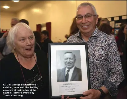  ?? ?? Lt. Col. George Saunderson’s children, Irene and Jim, holding a picture of their father at the night in Teemore. Photos by Trevor Armstrong.