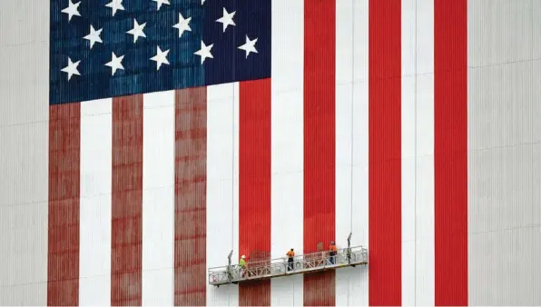  ?? Foto: John Raoux, dpa ?? Ein neuer Anstrich: Pünktlich zur Wahl in den Vereinigte­n Staaten frischen Arbeiter die Farben der amerikanis­chen Flagge am Kennedy Space Center in Cape Canaveral auf.