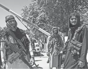  ?? WAKIL KOHSAR/AFP VIA GETTY IMAGES ?? Taliban fighters stand guard in Kabul, Afghanista­n, on Monday.