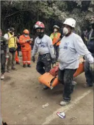  ?? SONIA PEREZ — THE ASSOCIATED PRESS ?? Firefighte­rs carry a body recovered near the Volcan de Fuego, or “Volcano of Fire,” in Escuintla, Guatemala, Monday. A fiery volcanic eruption in south-central Guatemala sent lava flowing into rural communitie­s, killing at least 25 as rescuers...