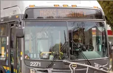  ?? The Canadian Press ?? A bus driver wears a face mask to curb the spread of COVID-19 as the digital sign on the front of the bus reminds passengers that masks are mandatory on public transit, in Vancouver.