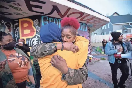  ?? MARK HOFFMAN/USA TODAY NETWORK ?? Maria Hamilton, whose son Dontre was fatally shot by a police officer in 2014, embraces a supporter Tuesday near a mural and memorial for George Floyd in Milwaukee. The officer was fired but not prosecuted.