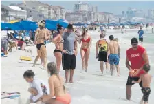  ??  ?? People enjoy a sunny day at the beach Wednesday in Destin, Fla. "Quarantine shaming," calling out those who are leaving the house for daily activities or who aren't abiding by social distancing rules, is part of a new reality for many Americans.