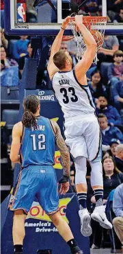  ?? [AP PHOTO] ?? Memphis’ Marc Gasol, right, dunks the ball in front of Oklahoma City’s Steven Adams during Thursday night’s NBA game in Memphis, Tenn.