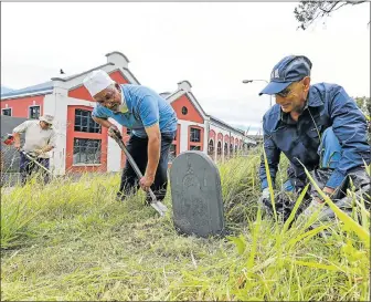  ?? Picture: WERNER HILLS ?? SAVING HERITAGE: Getting stuck in to clean up the South End cemetery, are from left, Isgaak Astrie and Abbas Agherdien from the Eastern Cape Malayo Cultural Society, and right, Ashraf Adam