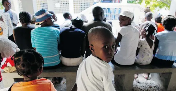  ?? PHIL CARPENTER/ THE GAZETTE ?? Patients wait for treatment by internatio­nal volunteers at the Family Health Ministries clinic in the Cité Soleil district of Port-au-Prince, seven days after an earthquake hit the country.