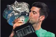  ?? Mark Dadswell / Associated Press ?? Serbia’s Novak Djokovic kisses the Norman Brookes Challenge Cup after defeating Russia’s Daniil Medvedev in the men’s singles final on Sunday at the Australian Open tennis championsh­ip in Melbourne, Australia.