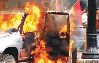  ??  ?? El fuego consume un vehículo frente a la Prefectura de Cochabamba, atacada y quemada en enero de 2007.