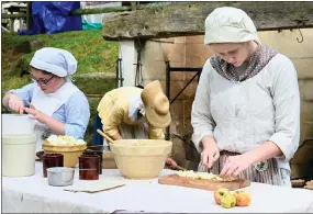  ?? JESI YOST — FOR MEDIANEWS GROUP ?? First-time volunteer Charlotte Thomas, 15, dices apples for fritters that are cooked on a skillet over an open hearth during the Hay Creek Festival, a three-day living history event at Joanna Furnace near Morgantown.