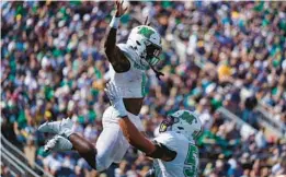  ?? MICHAEL CONROY/AP ?? Marshall offensive lineman Ethan Driskell, right, throws up receiver Cam Pedro as they celebrate a touchdown against Notre Dame on Saturday in South Bend, Ind.
