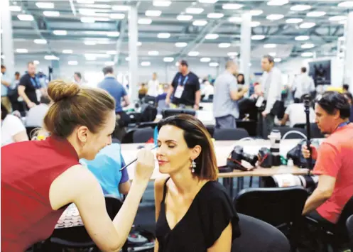  ??  ?? A Russian TV presenter has her make-up applied in the media centre at the Spartak stadium in Moscow, Russia, June 19, 2018 during the 2018 World Cup. REUTERS: Kai Pfaffenbac­h