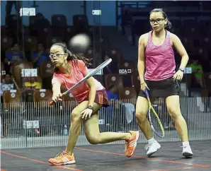  ??  ?? Over to you: Noor Aina Amani Ampandi (left) returning a shot to Wong Heng Wai during their semi-final match yesterday. — IZZRAFIQ ALIAS/ The Star