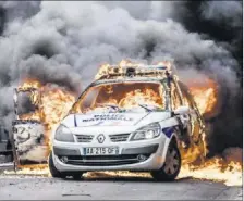  ?? (Photo AFP) ?? Les fonctionna­ires de police avaient pu s’extraire à temps du brasier de leur voiture.