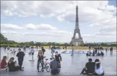  ?? ASSOCIATED PRESS ?? PEOPLE STROLL AT TROCADERO SQUARE near the Eiffel Tower in Paris, Monday, as France gradually lifts its COVID-19 lockdown.