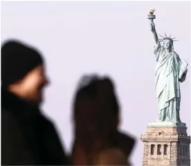  ?? PHOTO: AP ?? Tourists ride the Staten Island Ferry to get a view of the Statue of Liberty on Sunday in New York. The statue is presently closed due to the government shutdown.