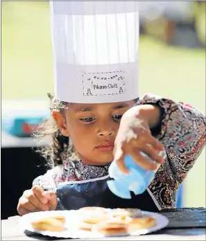  ?? Pictures: FREDLIN ADRIAAN ?? CIRCLES OF LIFE: Chef in the making Madison-Rose van Vuuren puts the finishing touches to her doughnuts at the KFC Herald Family Country Fair at Holmeleigh Farmyard