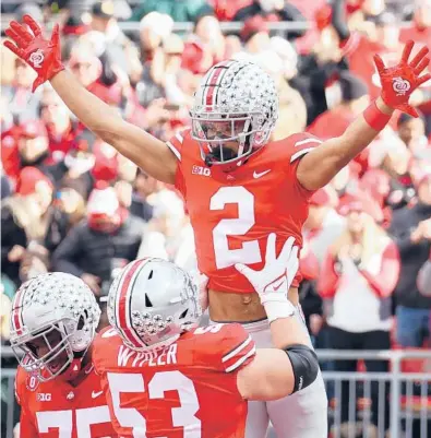  ?? GREGORY SHAMUS/GETTY ?? Ohio State’s Chris Olave (2) celebrates a touchdown catch with Luke Wypler (53) on Saturday at Ohio Stadium.