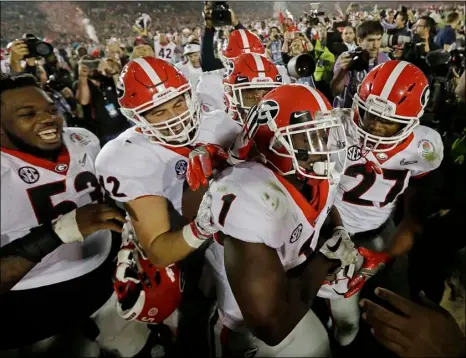  ?? AP PHOTO ?? Georgia tailback Sony Michel (center) celebrates with teammates after scoring the game-winning touchdown in the second overtime period to give Georgia a 54-48 win over Oklahoma in the Rose Bowl NCAA college football game Monday.