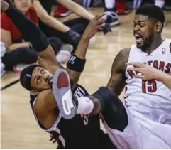  ??  ?? Toronto’s Amir Johnson draws a foul on Nets forward Paul Pierce, left, on Sunday