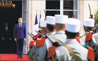  ?? GONZALO FUENTES AP ?? French President Emmanuel Macron reviews military troops during a ceremony at his inaugurati­on for a second term at the Elysee palace in Paris, France, on Saturday.