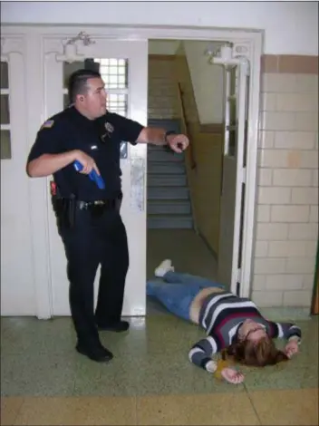  ?? KEVIN TUSTIN - DIGITAL FIRST MEDIA ?? A police officer locates a victim of a shooter on the second floor of the school.